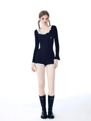 Full-body styling view of a black long-sleeve ruffle romper bodysuit with white frills and high-cut shorts silhouette