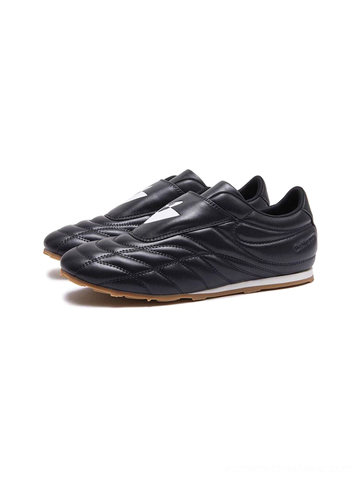 Black low-profile football trainer sneakers showing quilted panels, lace-up front, strap closure, and gum outsole