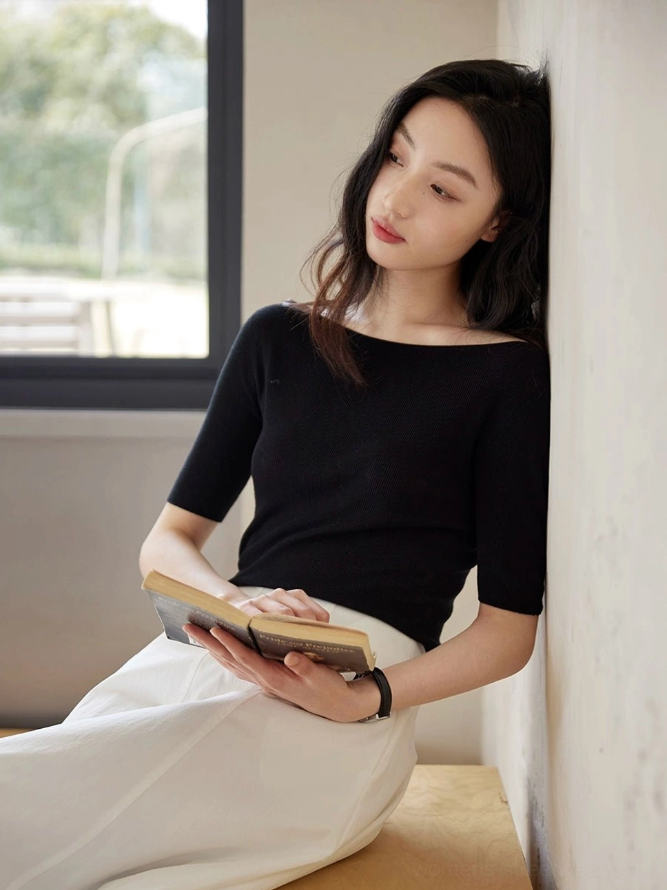 Close up of black lyocell silk boat neck half sleeve knit top showing subtle ribbed texture and fitted silhouette