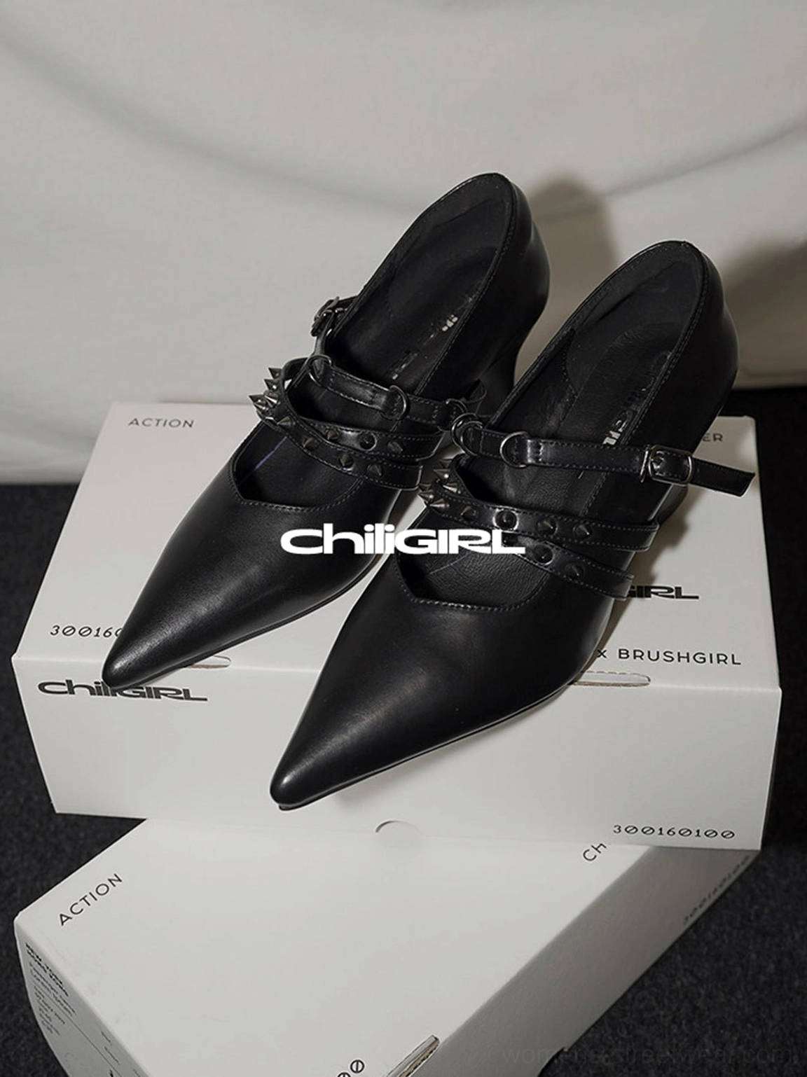 Black matte pointed toe wedge pumps with double decorative buckle straps and a sleek low wedge heel