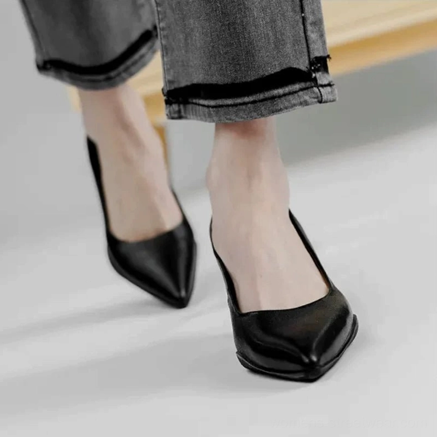 Black matte leather pointed-toe kitten heel pumps styled with cropped dark denim jeans