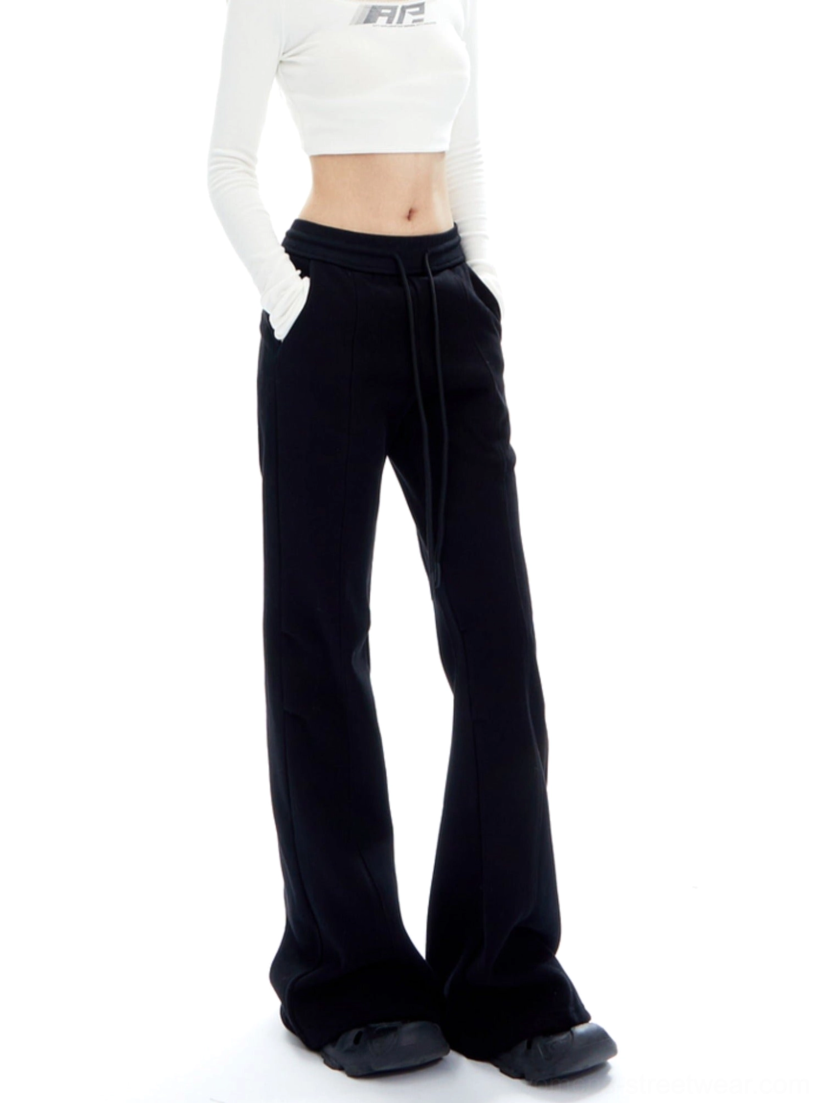 Three-quarter side view of black minimalist flared streetwear pants with floor-length wide-leg hem