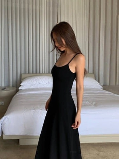 Black minimalist maxi dress with thin spaghetti straps and a long streamlined slip dress silhouette