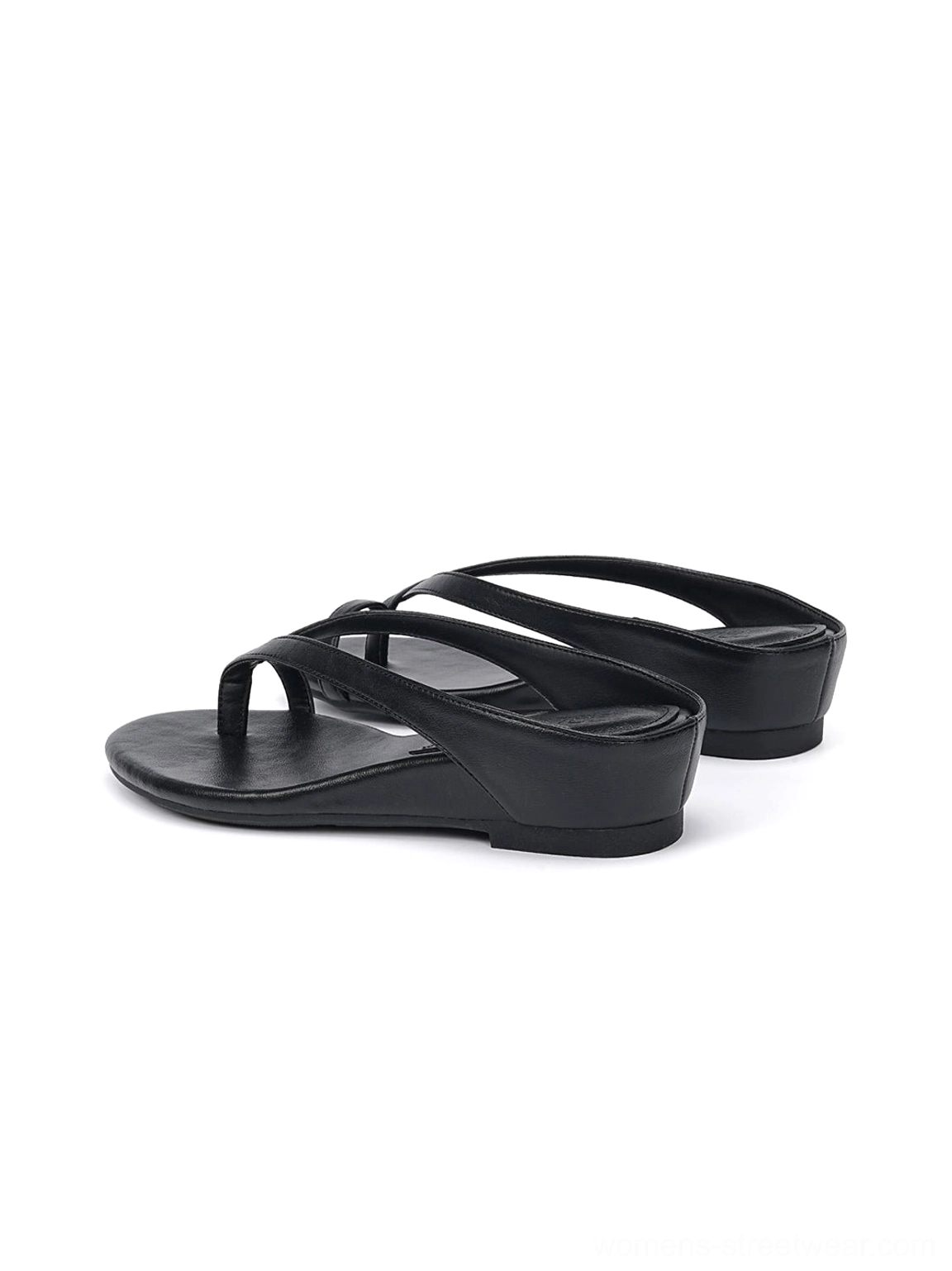 Pair of black minimalist low wedge flip-flop sandals with slim toe ring straps on white background