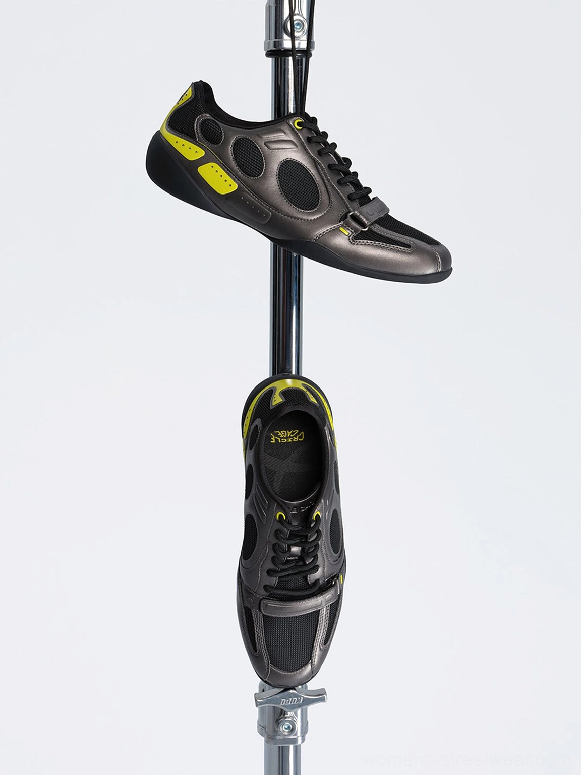 45-degree product view of black retro colorblock low-profile sneakers showing the lace-up design, front strap, mesh panels, and neon accents