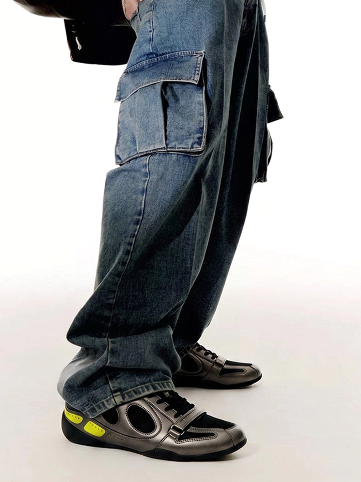 Black gunmetal and neon yellow retro colorblock sneakers paired with baggy blue denim cargo jeans in a casual street style look