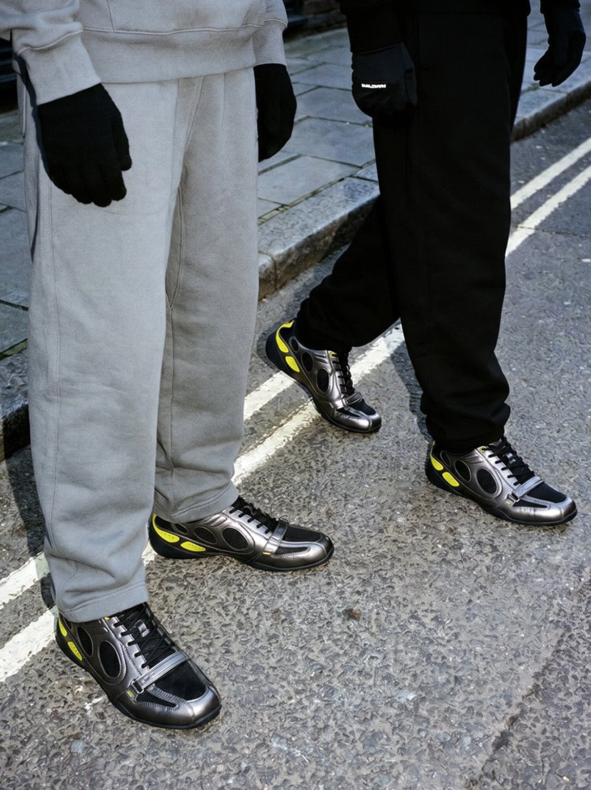 Retro black and neon yellow low-profile sneakers styled with grey cargo sweatpants and all-black streetwear outfits
