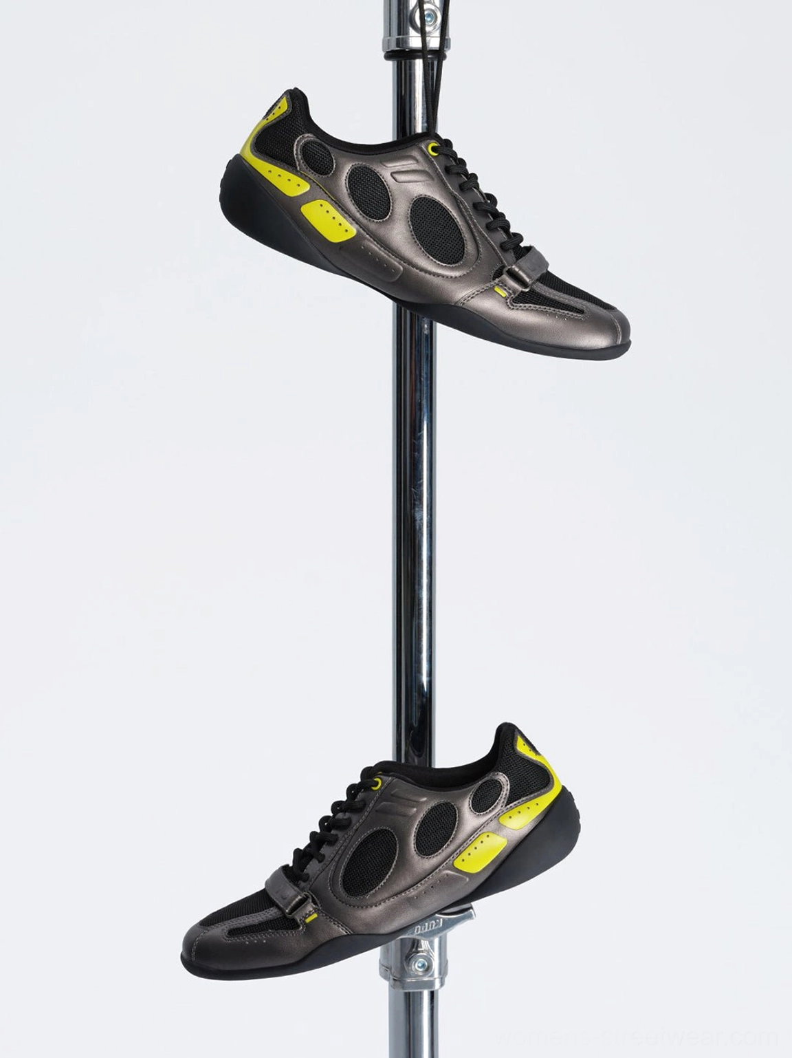 Top-down view of black and neon yellow retro low-profile sneakers showing the rounded toe, front strap, laces, and colorblocked upper