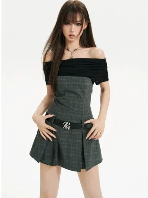 Front view of a black off shoulder plaid mini dress with ruched neckline, tailored waist, pleated A line skirt, and two tone Korean streetwear styling
