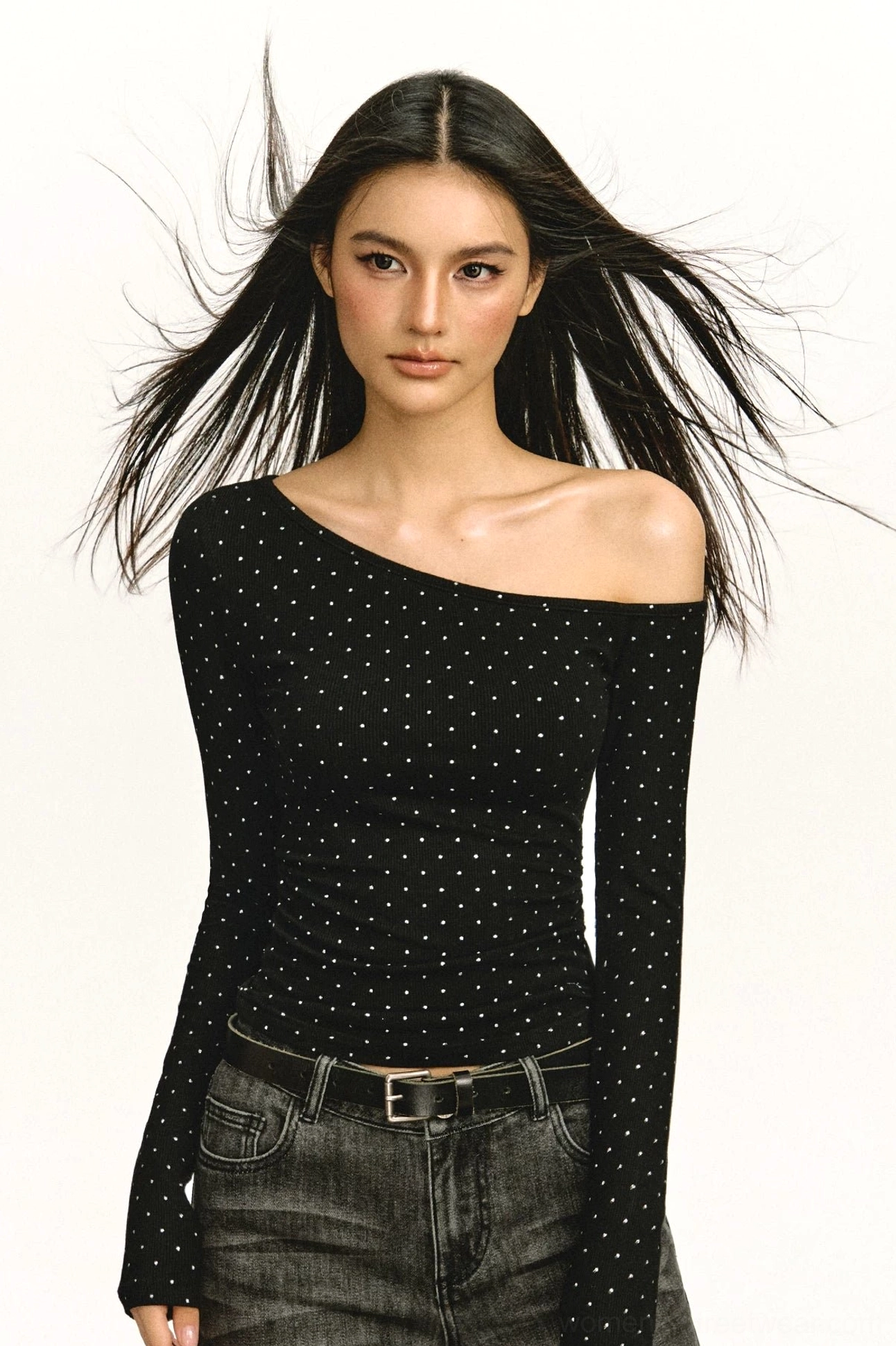 Black off-shoulder ruched long-sleeve top with subtle dot pattern styled with dark wash jeans