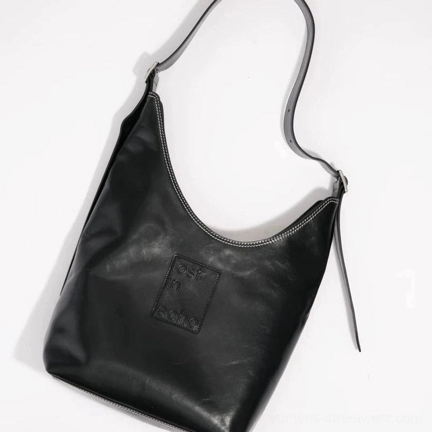 Black oil-wax leather and canvas oversized commuter tote bag with contrast stitching and adjustable shoulder strap