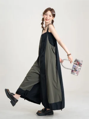 Side three-quarter view of an oversized black and olive balloon-leg jumpsuit styled with platform shoes and a streetwear bucket bag