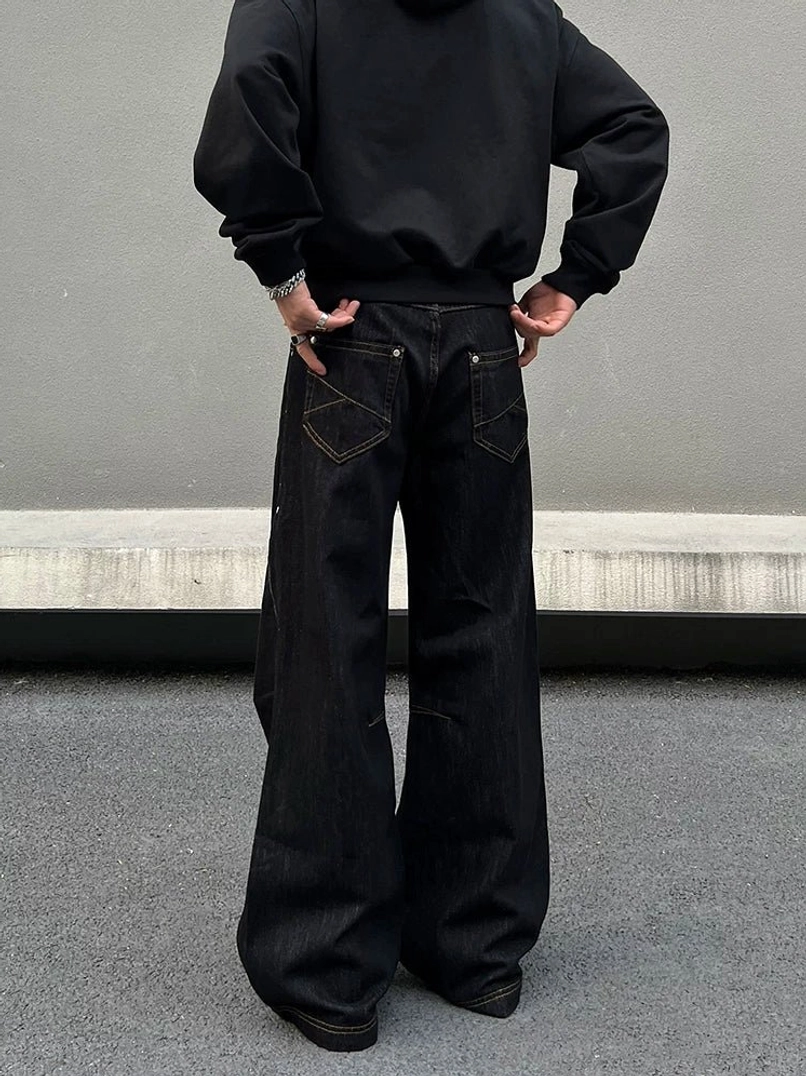 Rear view of black baggy wide-leg jeans with dual contrast-stitched back pockets and full-length oversized denim silhouette