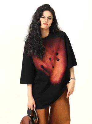 Black oversized abstract smiley graphic T-shirt three quarter front view showing relaxed streetwear fit