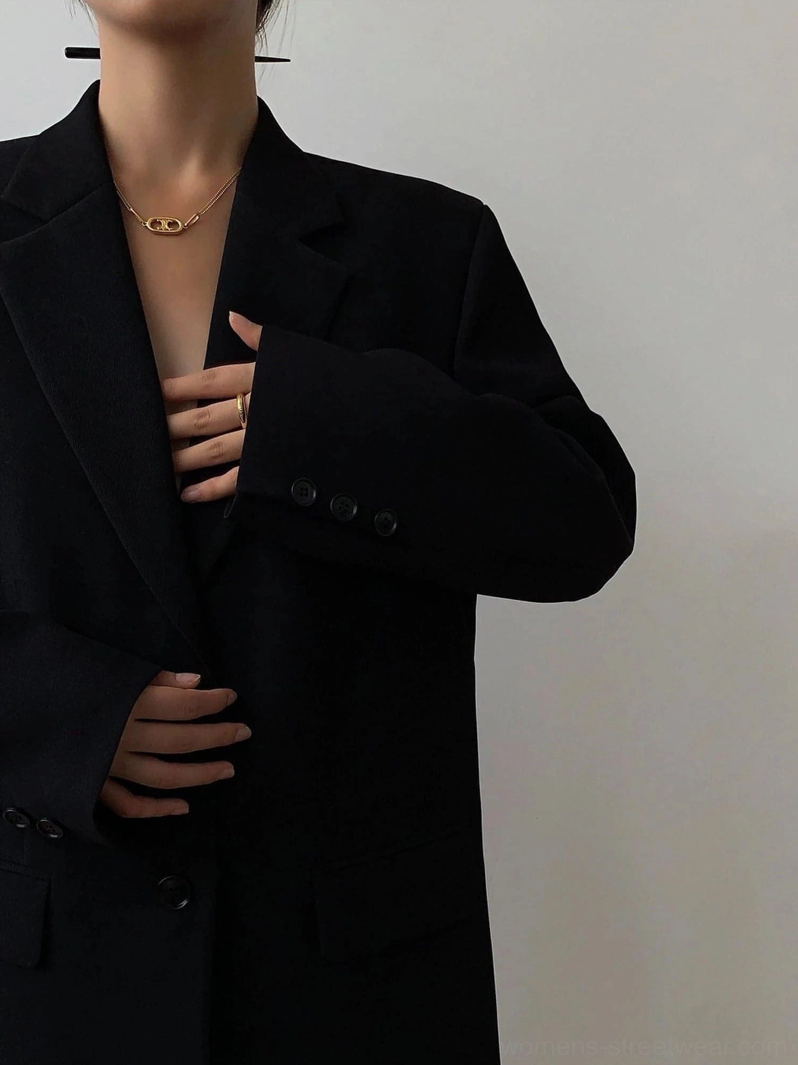 Black oversized blazer close-up upper torso cuff buttons single-breasted closure matte fabric