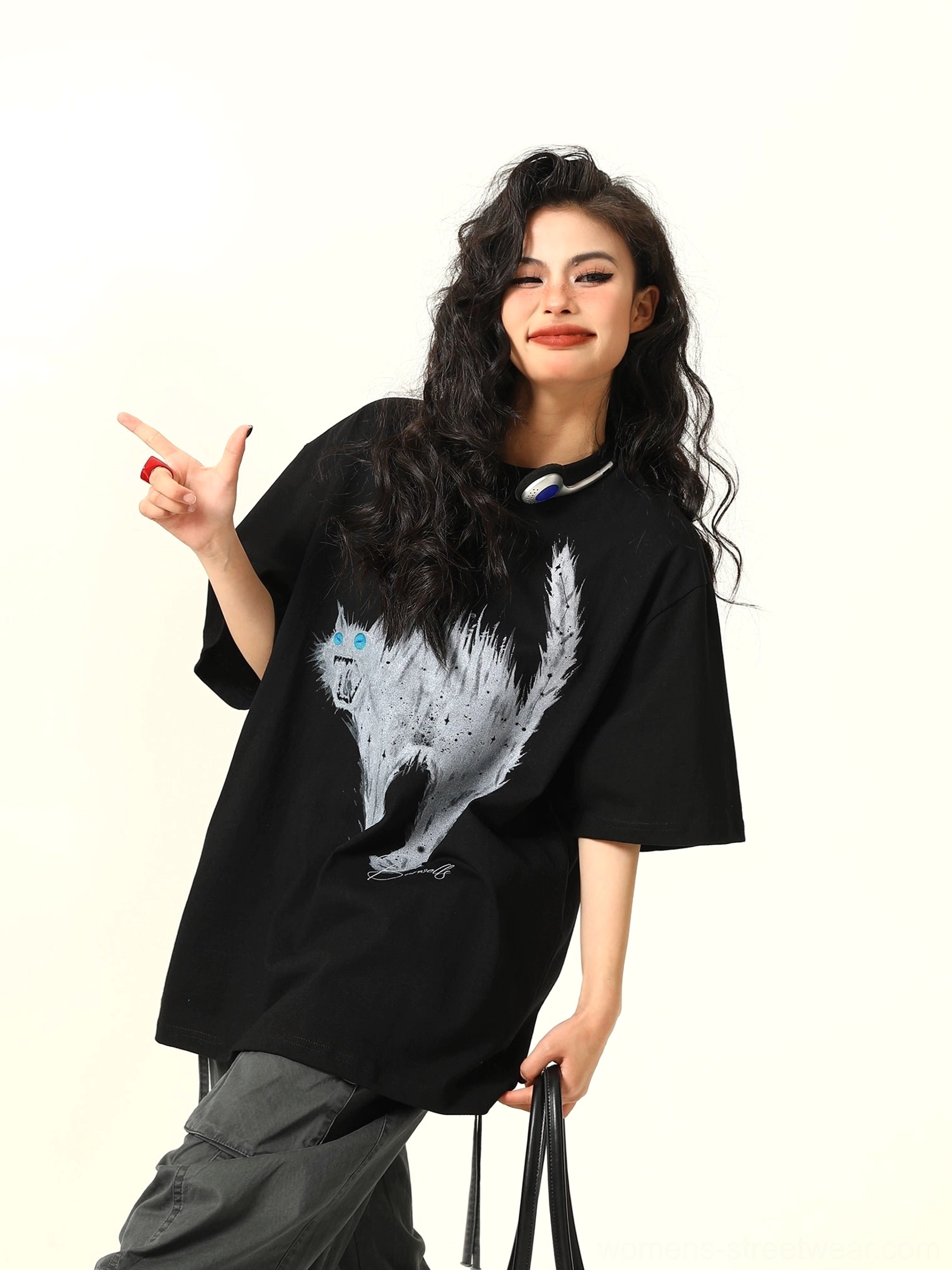 Three-quarter front view of a black oversized streetwear T-shirt with white angry cat graphic, classic crew neck, and relaxed loose fit