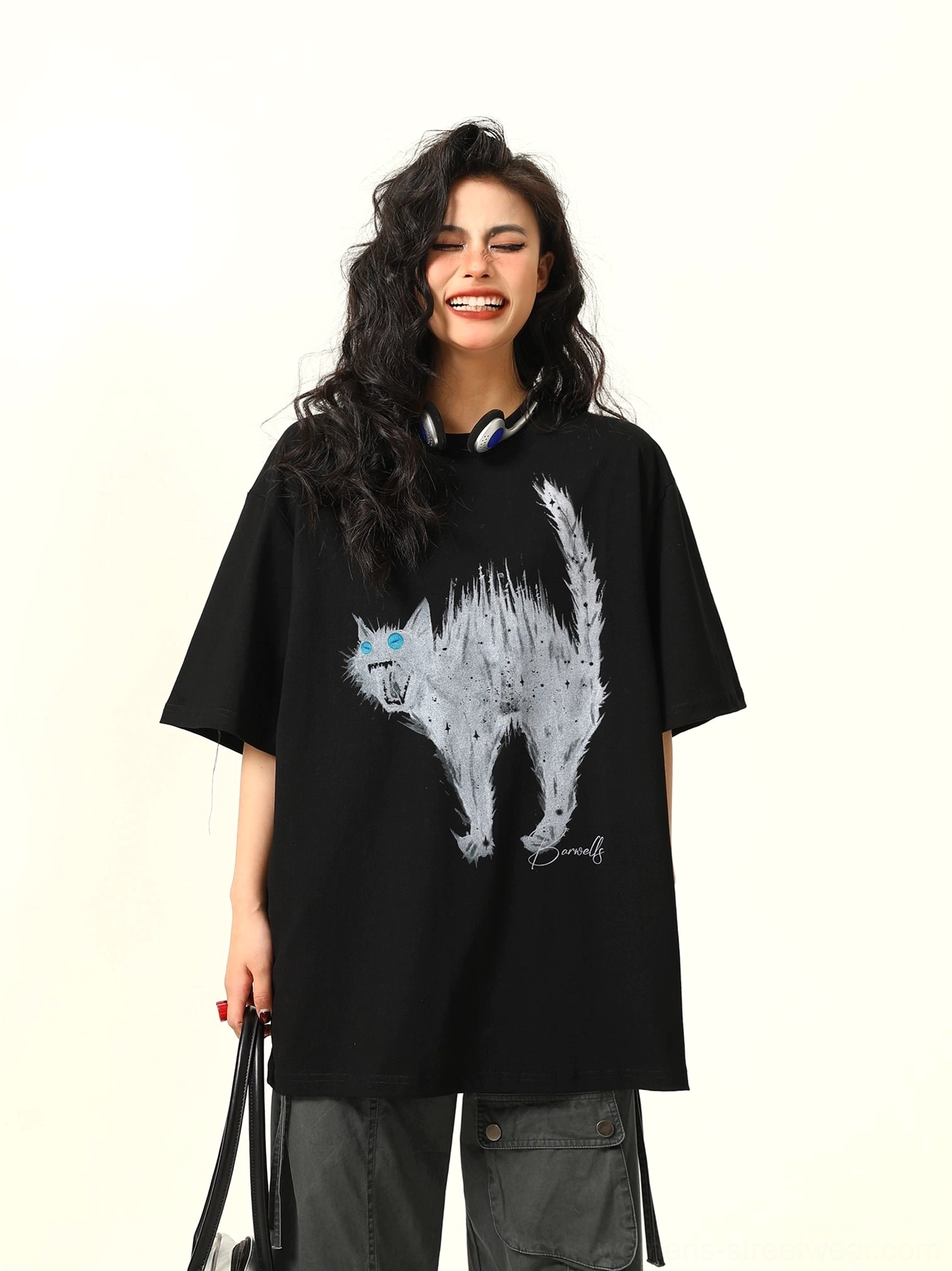 Straight front view of a black oversized cat graphic T-shirt with white sketch artwork, electric blue eyes, drop shoulders, and short sleeves