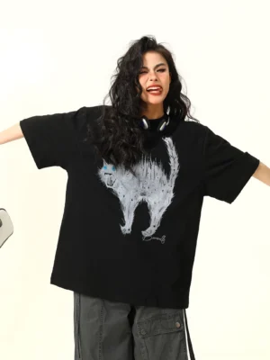 Close-up front view of a black oversized cat graphic T-shirt with white sketch-style angry cat artwork and electric blue eyes, styled with dark cargo pants