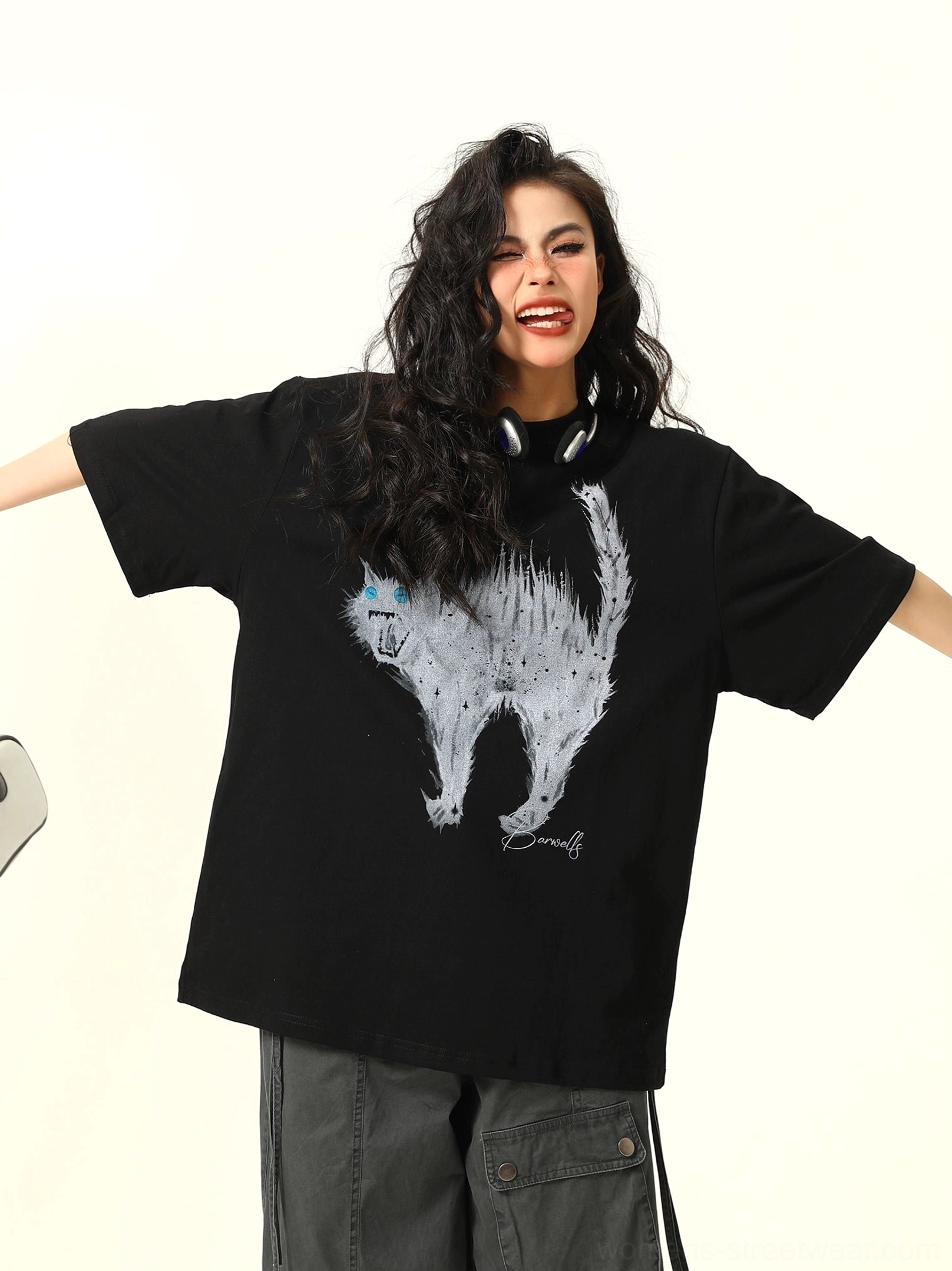 Close-up front view of a black oversized cat graphic T-shirt with white sketch-style angry cat artwork and electric blue eyes, styled with dark cargo pants