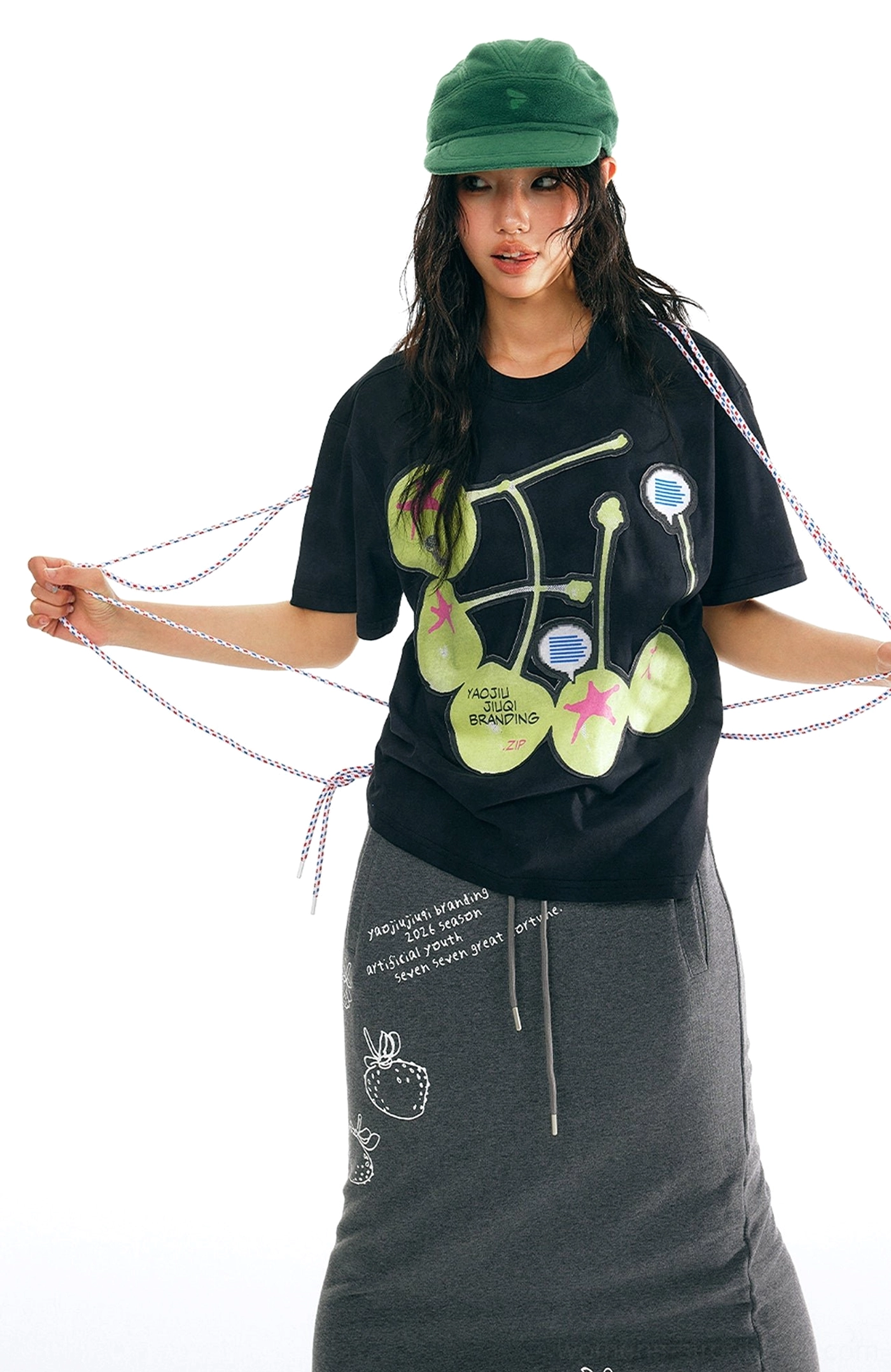 Black oversized cherry graphic cotton t-shirt three-quarter model view with lime green cherries and relaxed streetwear fit