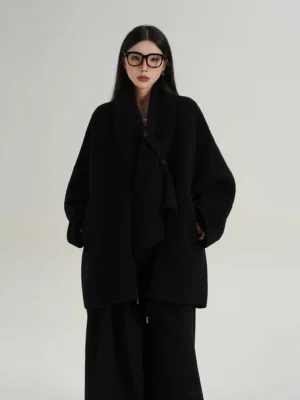 Black oversized cocoon wool jacket with draped shawl collar, dropped shoulders, wide sleeves, side pockets, and mid-thigh Korean streetwear silhouette