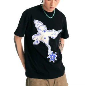 Black oversized crane graphic cotton T-shirt on male model with contrasting blue and off-white artwork, khaki trousers, and turquoise necklace