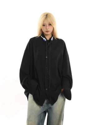 Black oversized draped button-down streetwear shirt shown in a full-body front view with a classic collar, relaxed drop sleeves, and wide-leg washed jeans