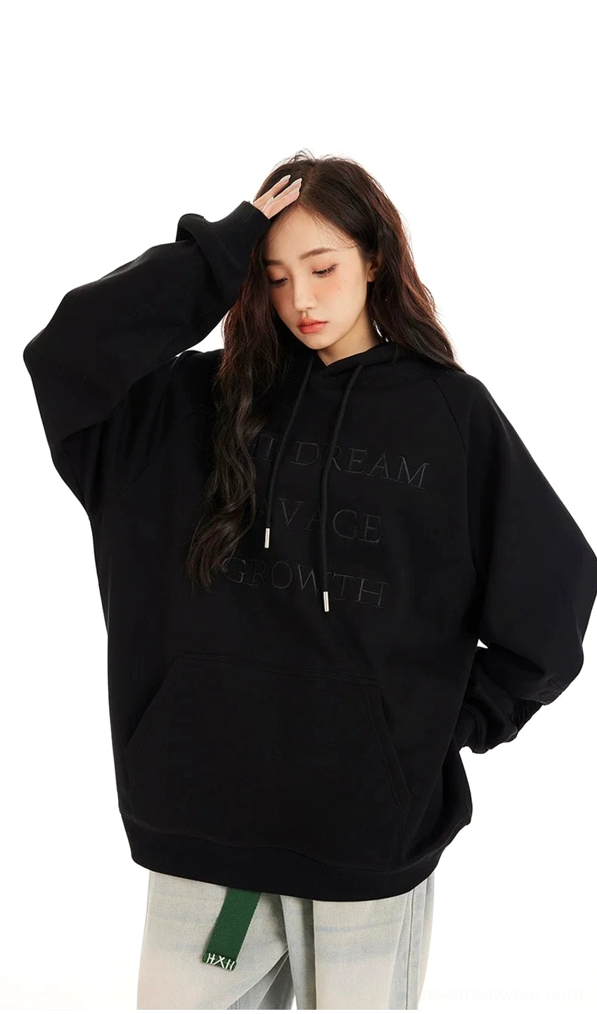 Side view of a black oversized embossed lettering hoodie with kangaroo pocket, drawstring hood, and relaxed dropped-shoulder silhouette