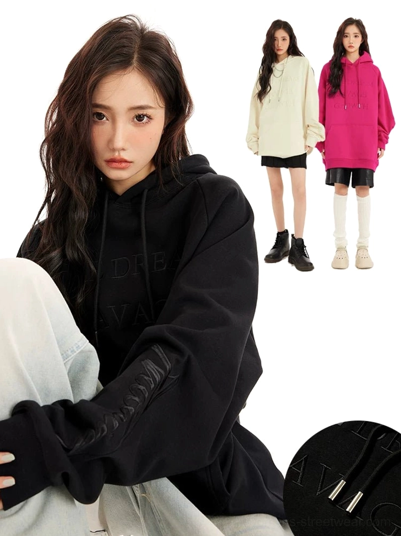 Black oversized embossed lettering hoodie shown in a relaxed side view with tonal graphics, metal-tipped drawstrings, and dropped shoulders