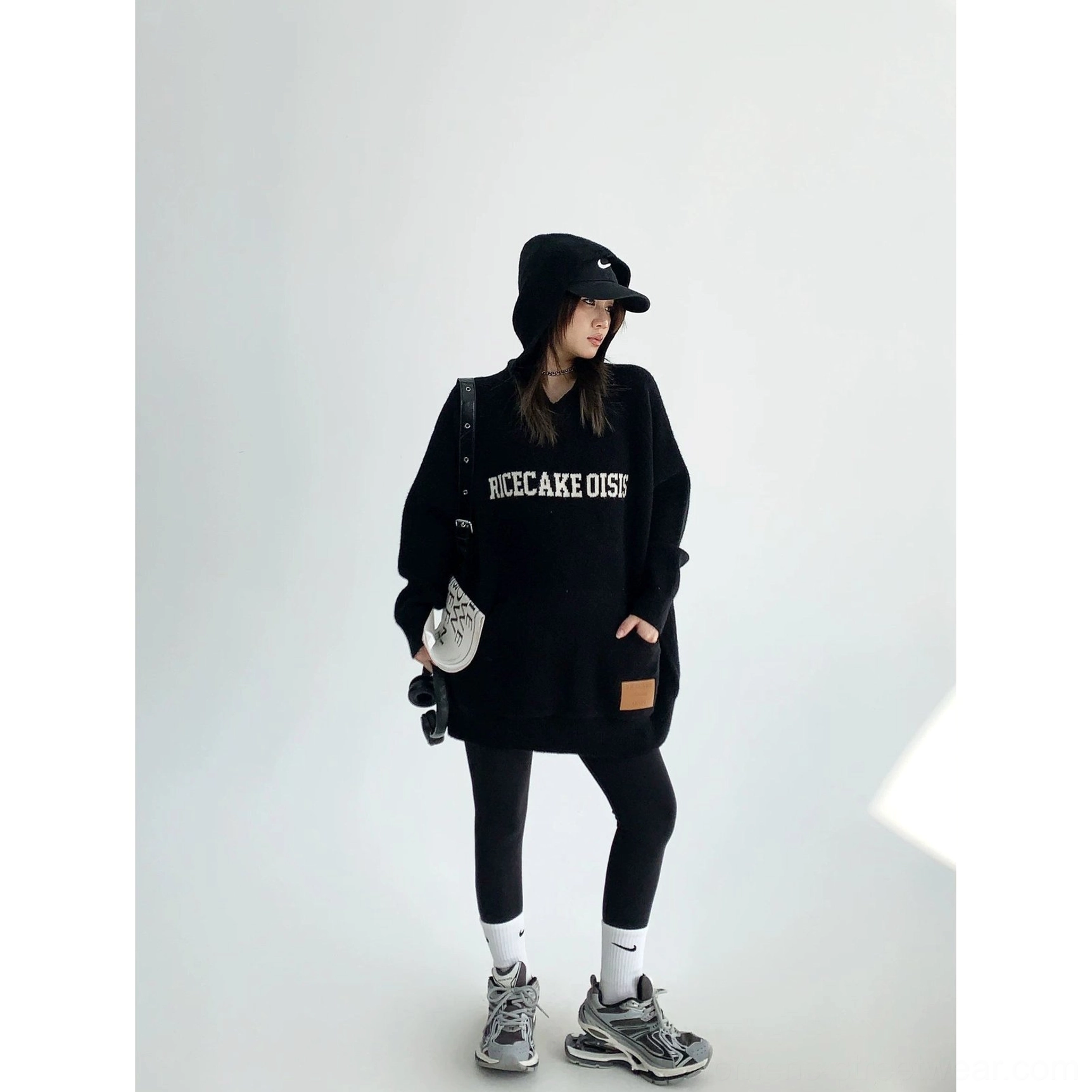 Black oversized graphic knit hoodie with contrast chest lettering, soft thick knit fabric, kangaroo pocket, and streetwear silhouette