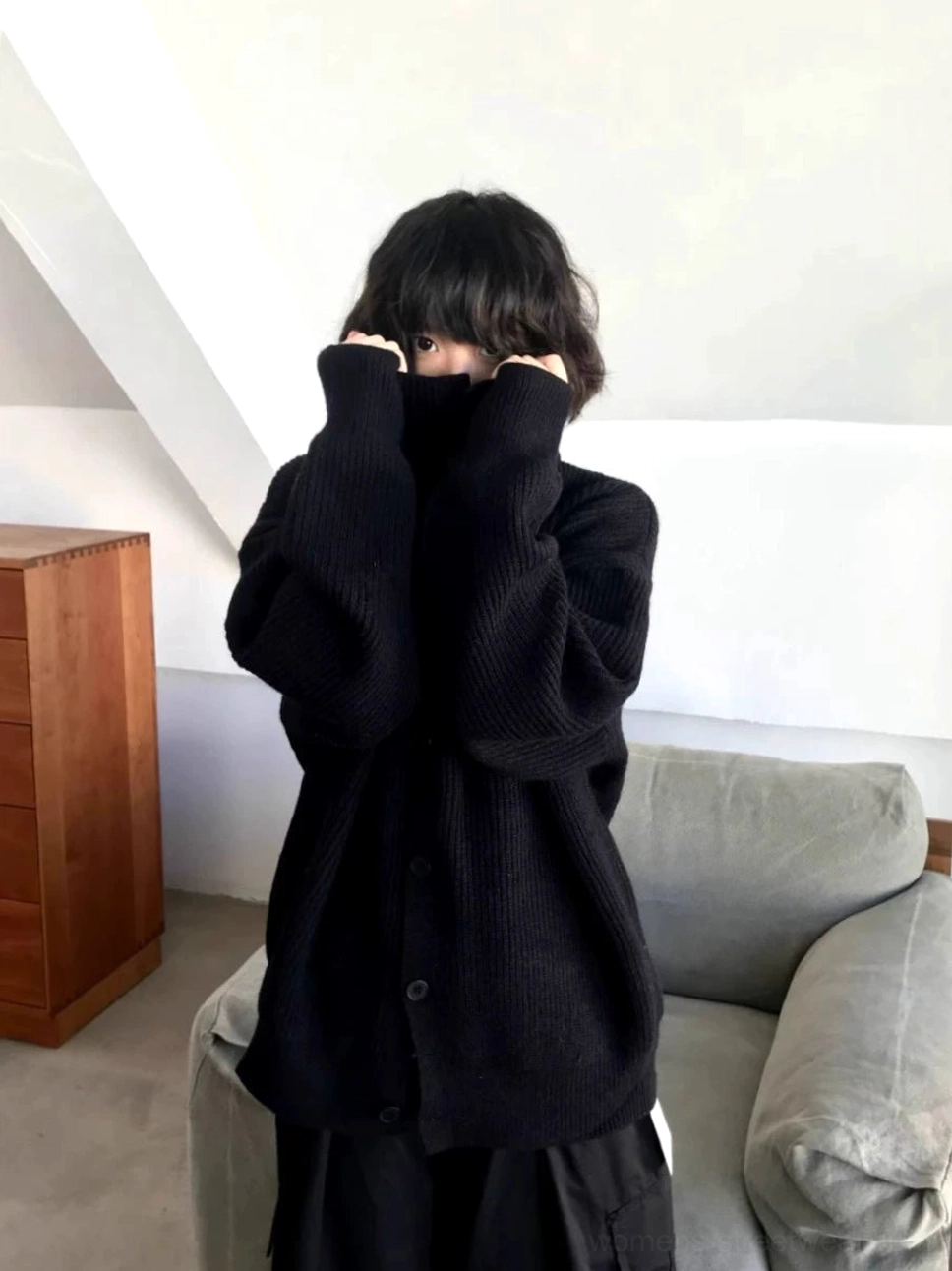 Black oversized knit cardigan sweater with long sleeves and raised collar styled in a relaxed urban streetwear outfit