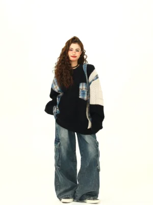 Back three-quarter view of black oversized patchwork cable knit sweater with plaid panels and crew neck