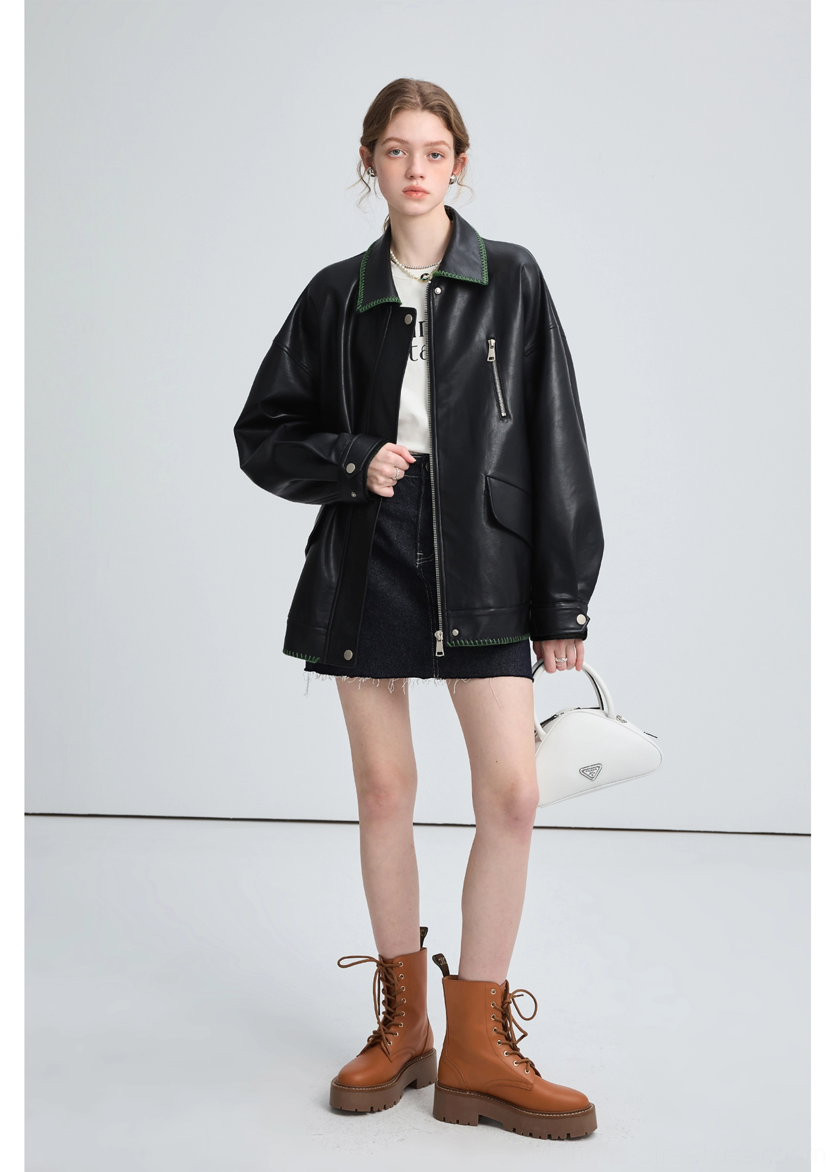 Black oversized PU leather biker jacket with green contrast stitching and modern Korean streetwear silhouette