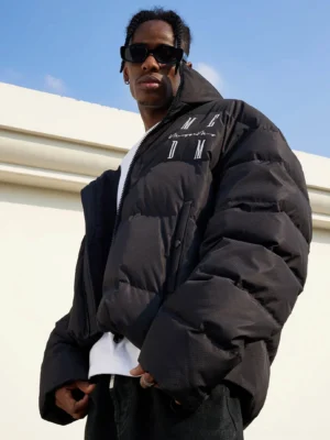 Black oversized puffer jacket styled with a white T-shirt and black pants in a contemporary outdoor streetwear look