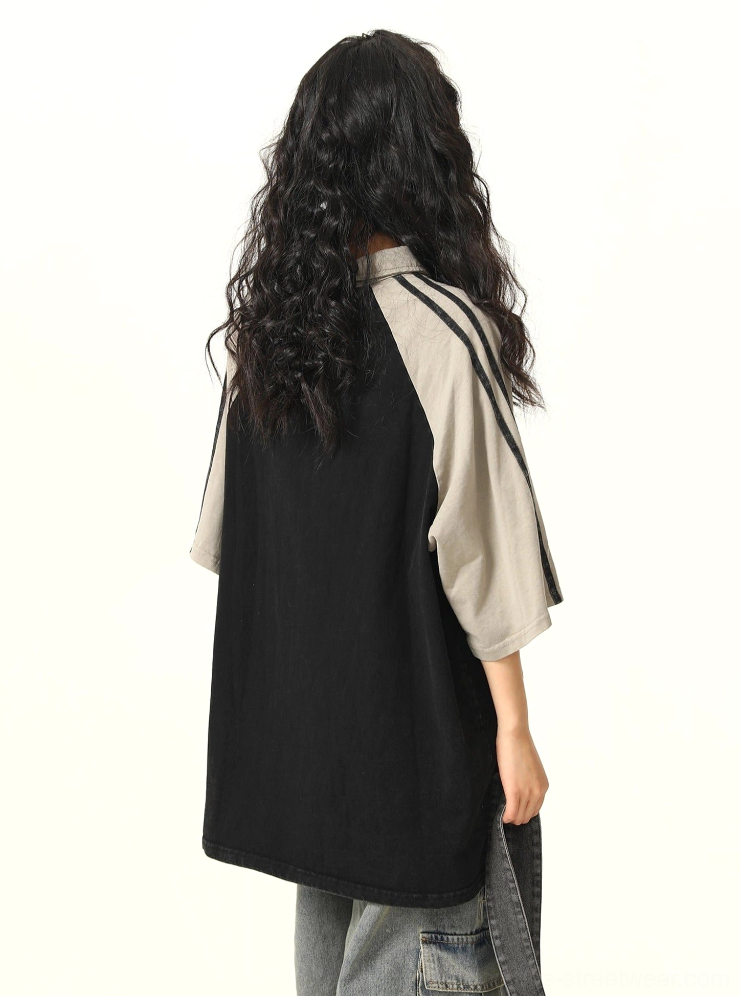 Back view of black oversized contrast raglan polo shirt featuring grey striped sleeves and a clean vintage sportswear silhouette