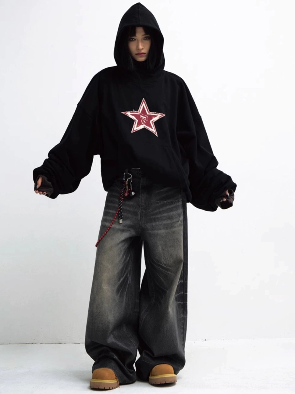 Full front view of a black oversized red star hoodie styled with wide-leg jeans and tan work boots
