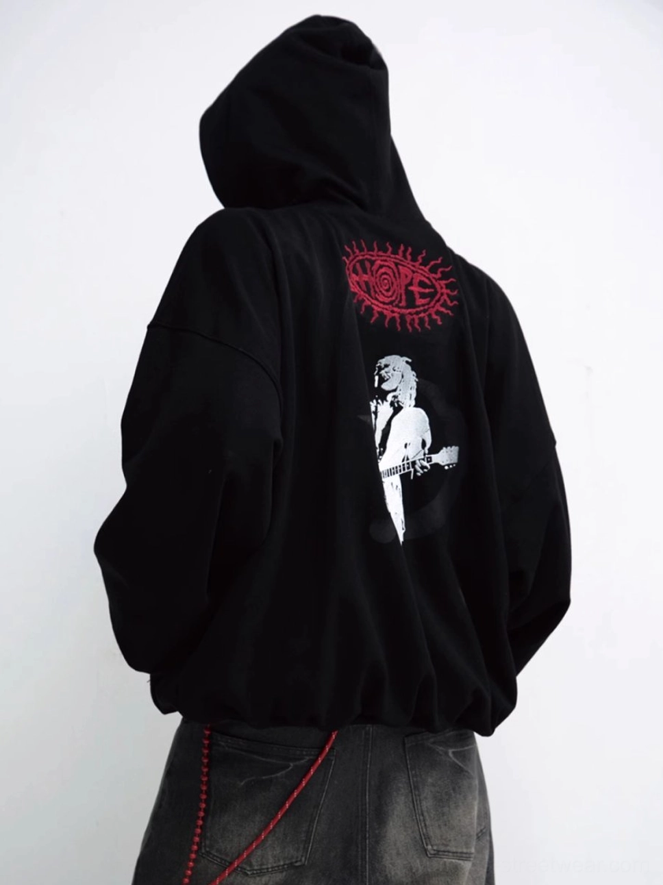 Side back view of black oversized red star hoodie with white musician graphic and circular back print