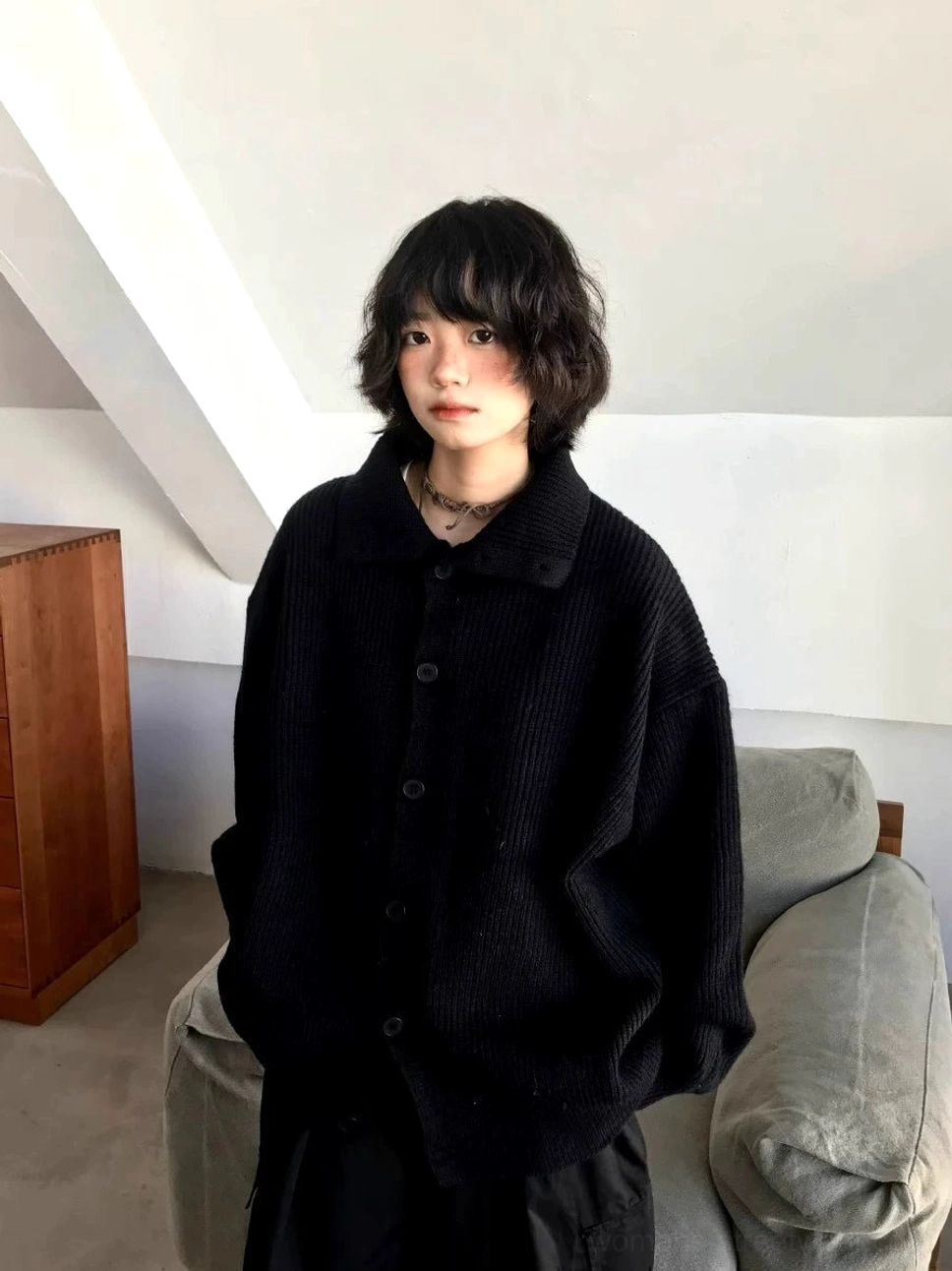 Black oversized cardigan sweater with ribbed knit texture, relaxed fit, and button-up front shown in full length