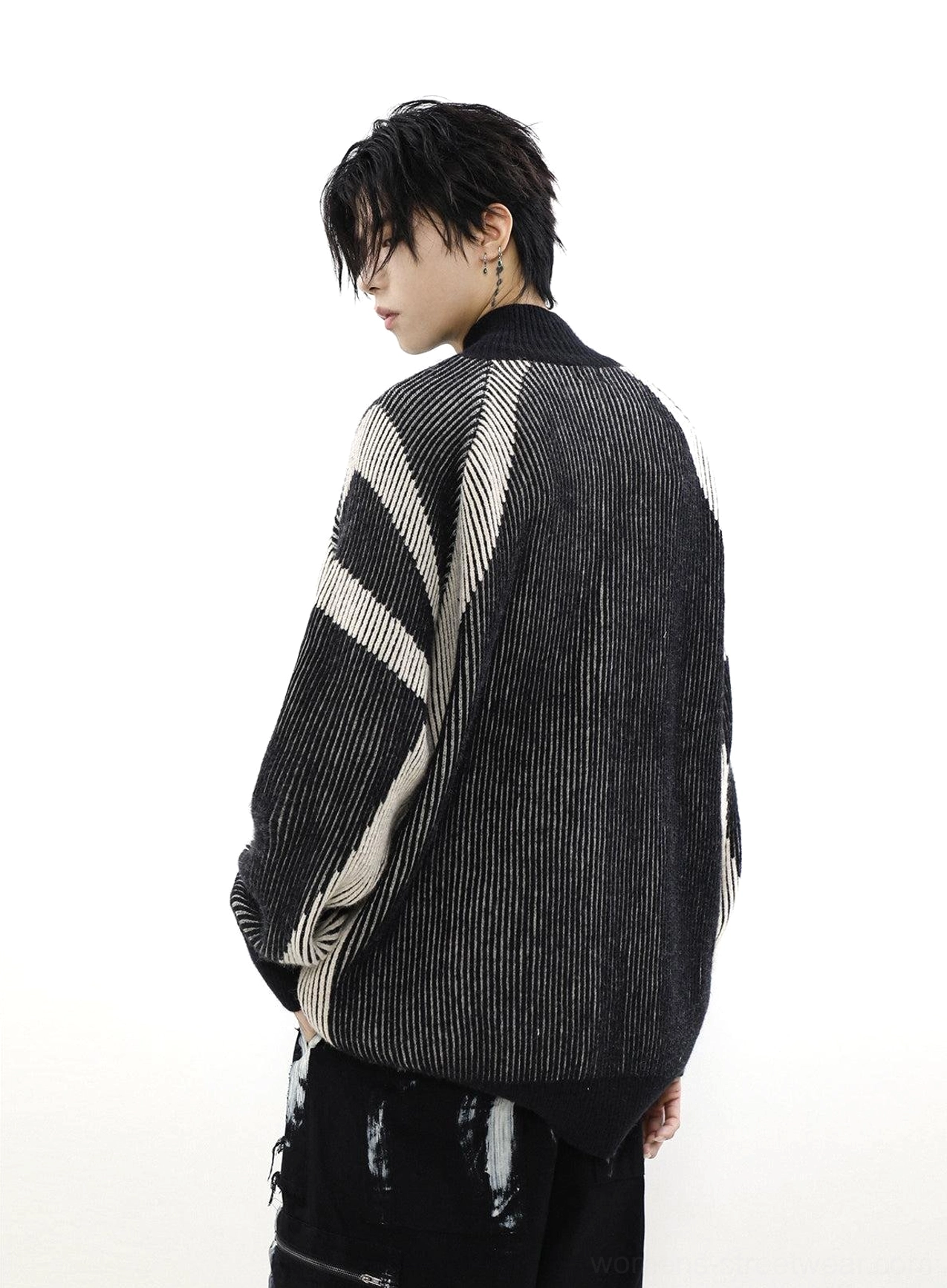 Back three-quarter view of a black oversized ribbed knit cardigan with contrast sleeve stripes and loose streetwear silhouette