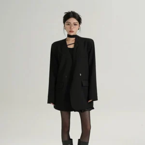 Black oversized scarf-collar blazer with double-breasted front, softly structured shoulders, neck strap detail, and side flap pockets styled as Seoul streetwear