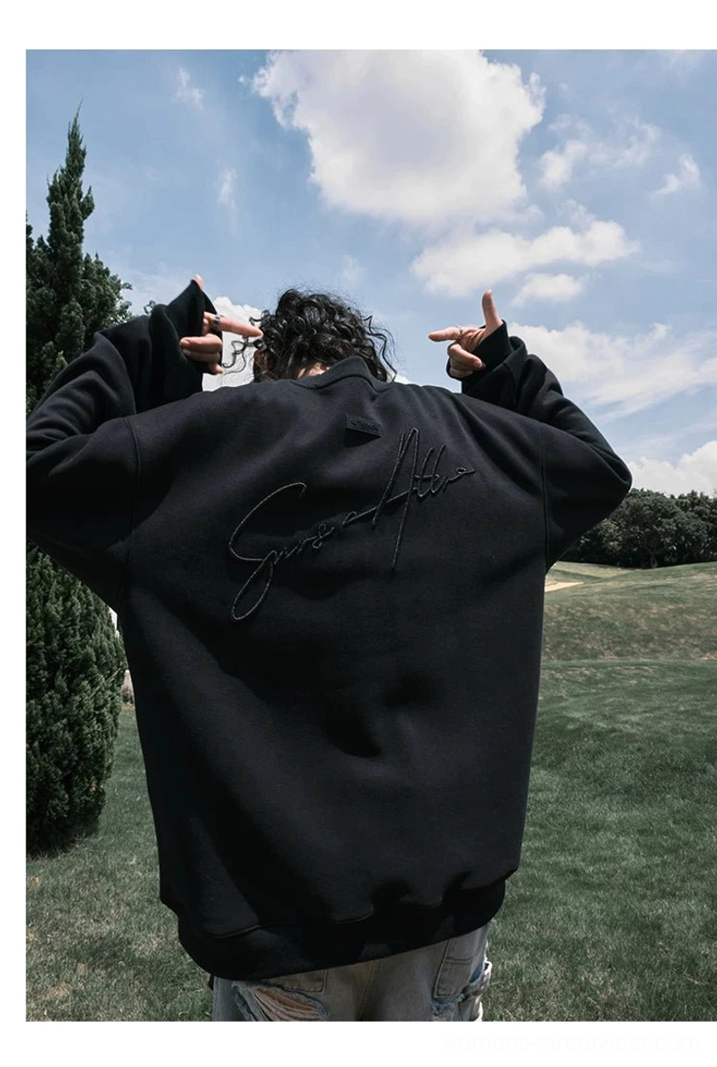 Black oversized script embroidered sweatshirt shown from the rear with long loose sleeves and a relaxed baggy streetwear silhouette