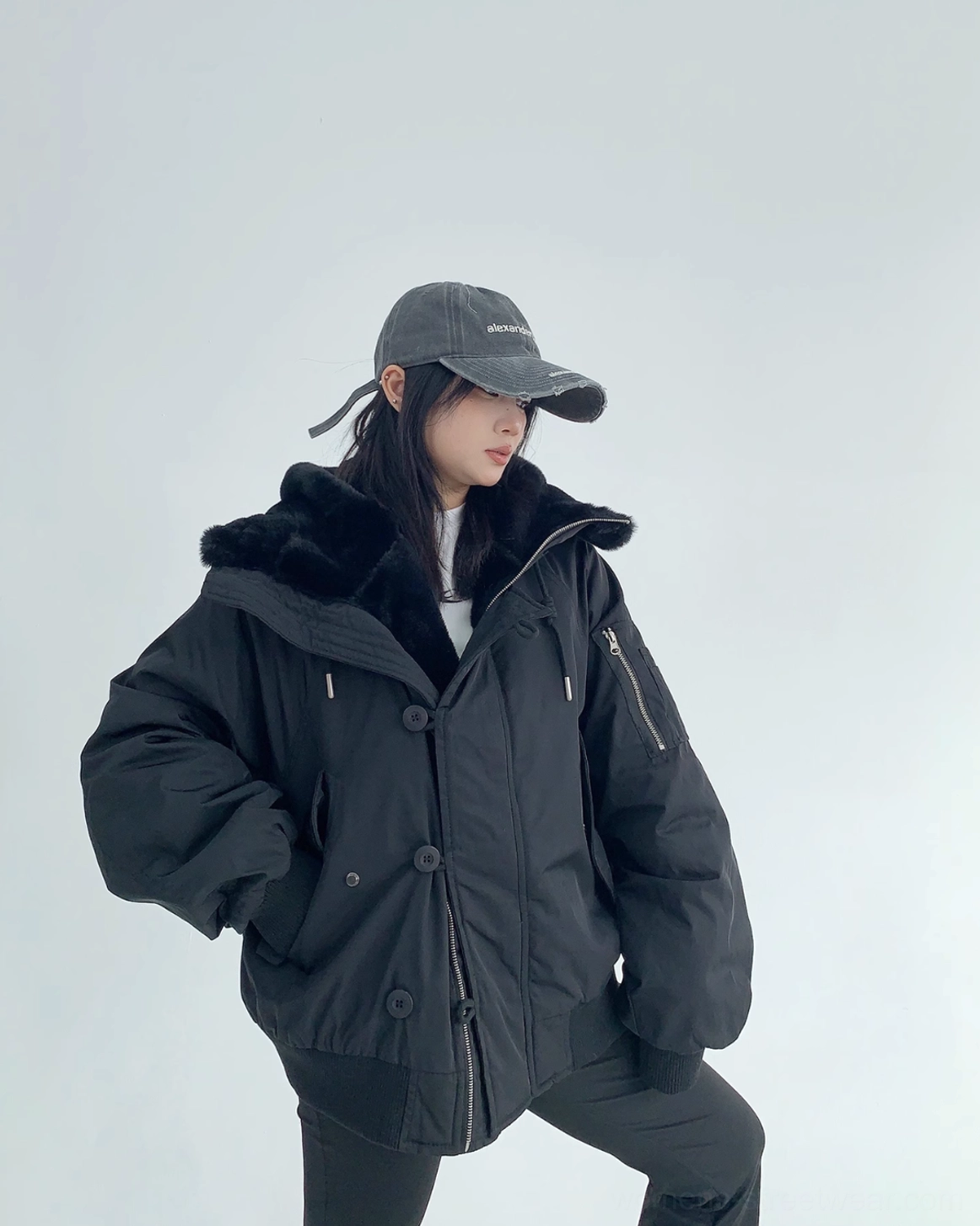 Black oversized sherpa-lined bomber jacket with hood, faux-shearling interior, ribbed cuffs, and modern urban styling