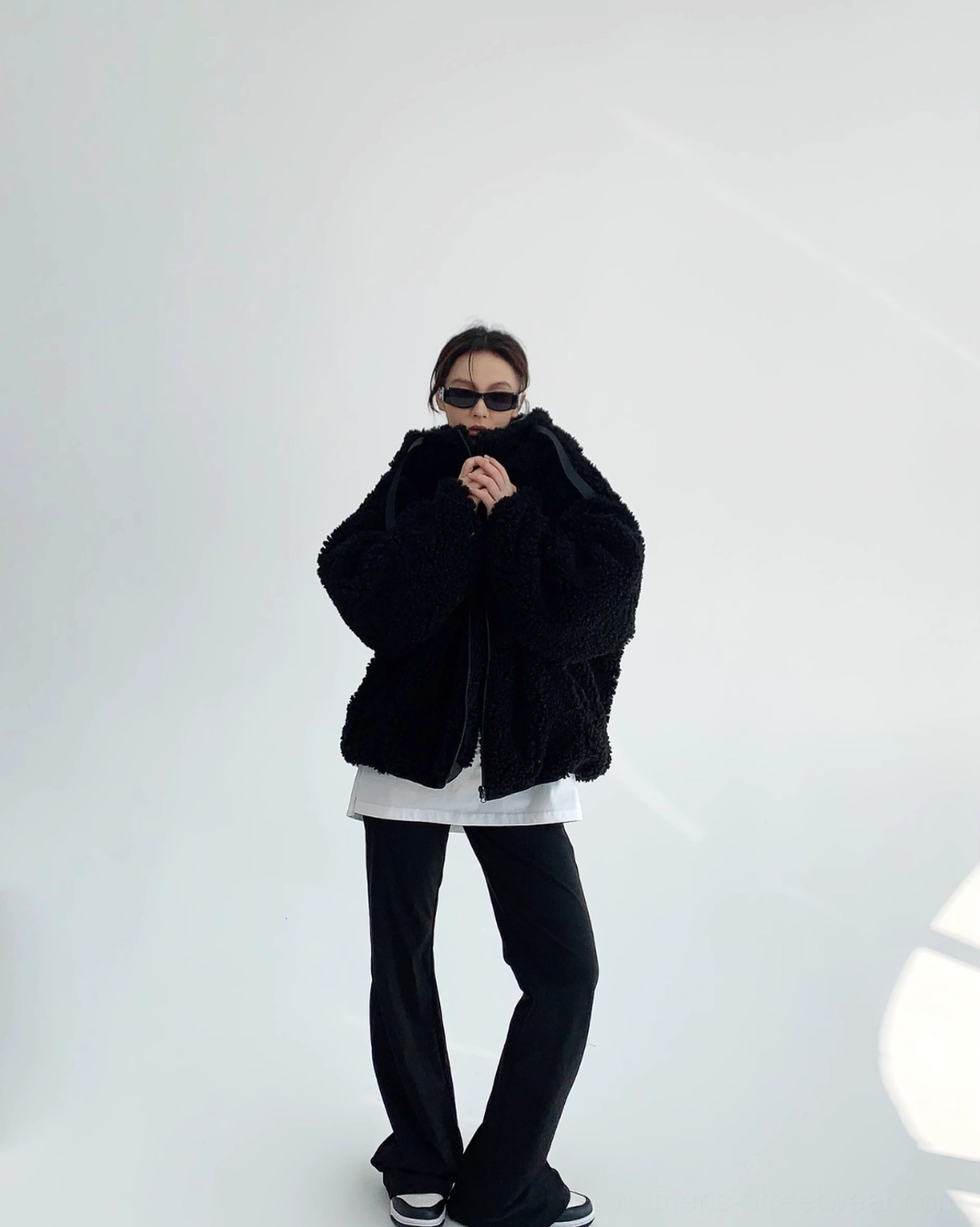 Full-body styling view of black oversized sherpa zip hoodie worn with white tee, black wide-leg pants, sneakers, and contemporary Seoul streetwear accessories