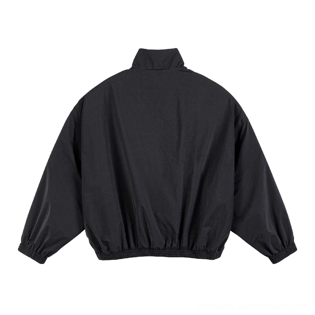 Back view of black oversized streetwear windbreaker jacket with relaxed dropped sleeves and elastic hem