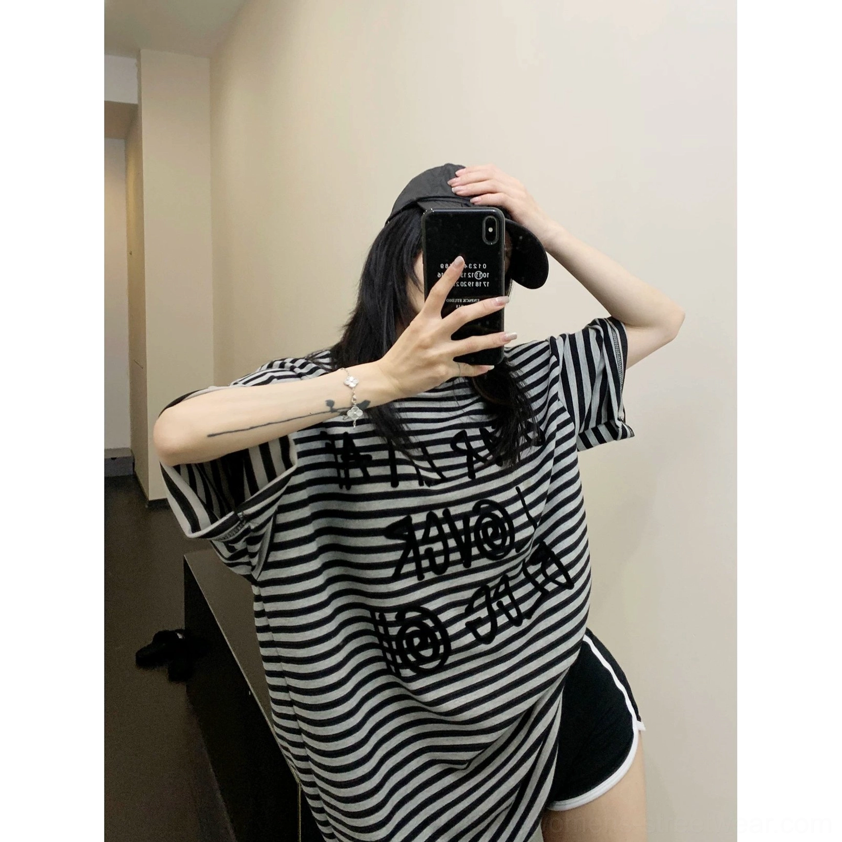 Black oversized striped graphic T-shirt with raised front lettering, relaxed crew neck, and contemporary Korean streetwear silhouette