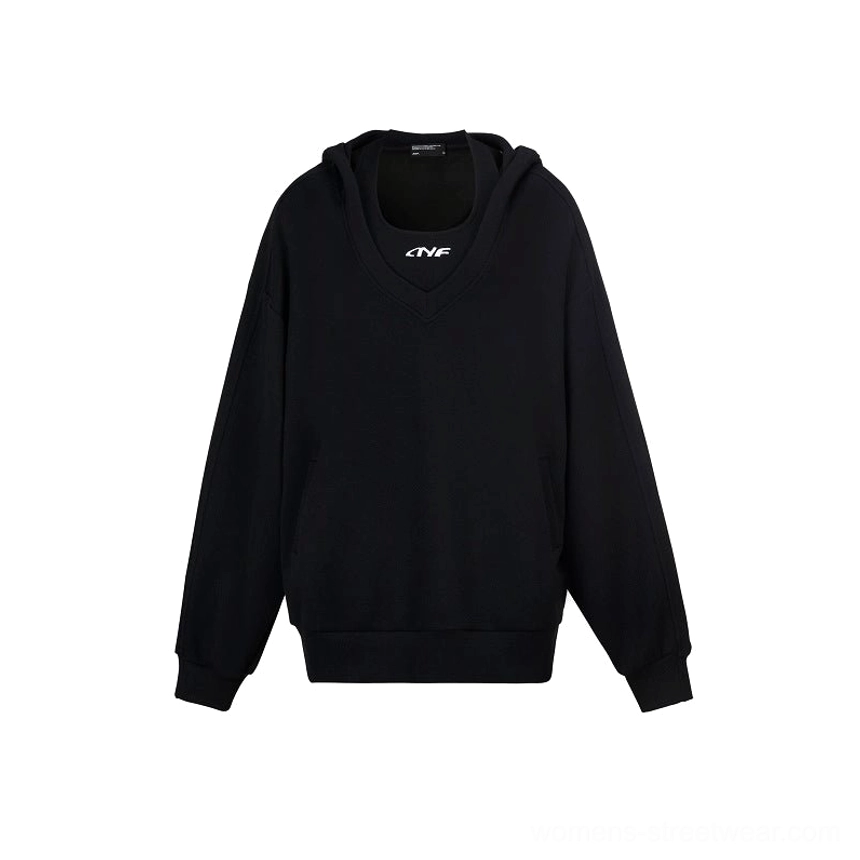 Black oversized V-neck hoodie sweatshirt flat lay showing kangaroo pocket, ribbed cuffs, ribbed hem, and subtle chest emblem