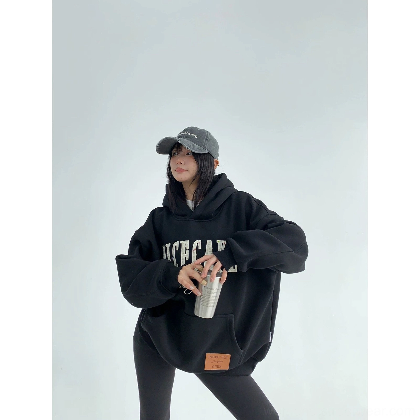 Black oversized varsity-inspired hoodie with front layered lettering, kangaroo pocket, heavyweight fleece fabric, and relaxed fit