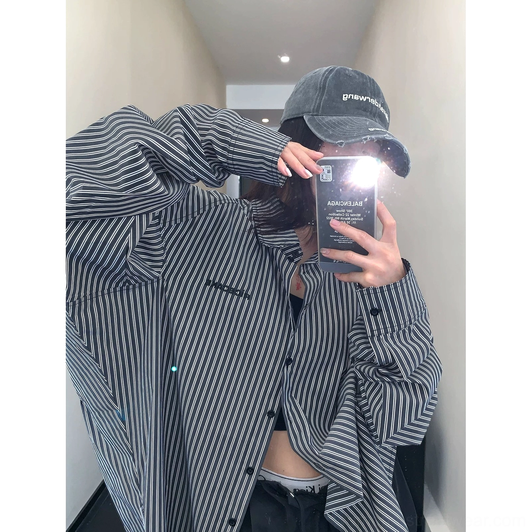 Back side view of black oversized vertical stripe shirt showing dropped shoulder construction and lightweight cotton fabric