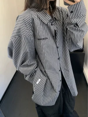Back three-quarter view of black and white oversized striped button-up shirt with dropped shoulders and relaxed streetwear fit