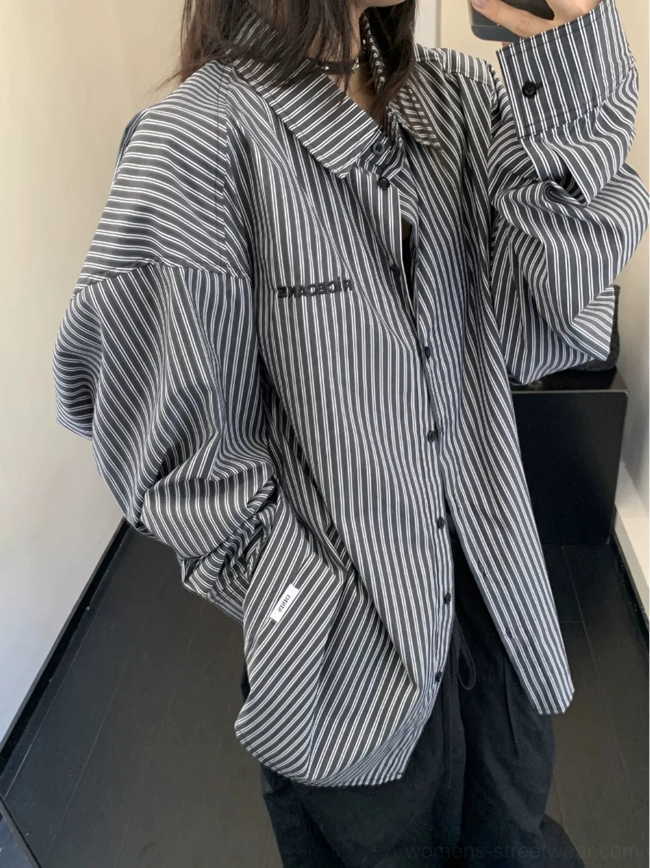 Back three-quarter view of black and white oversized striped button-up shirt with dropped shoulders and relaxed streetwear fit